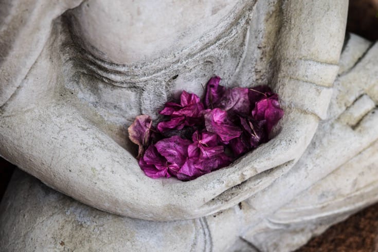 Buddha statue holding flowers.