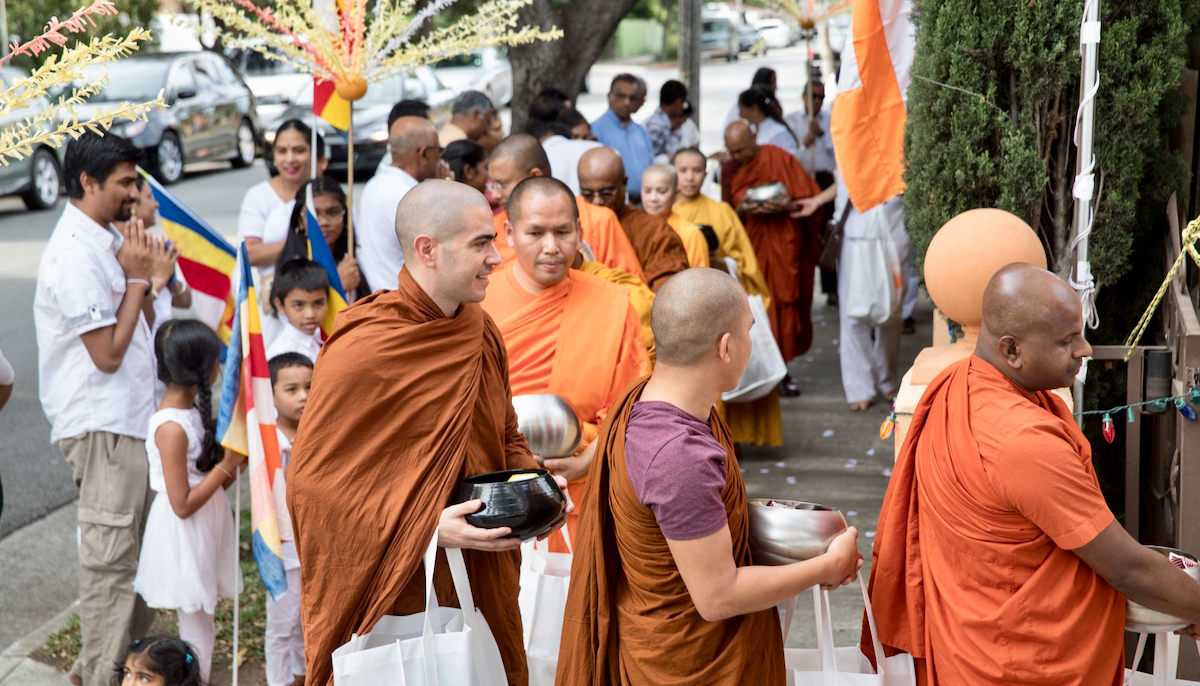 Monks in orange robes walking on alms rounds in Los Angeles.