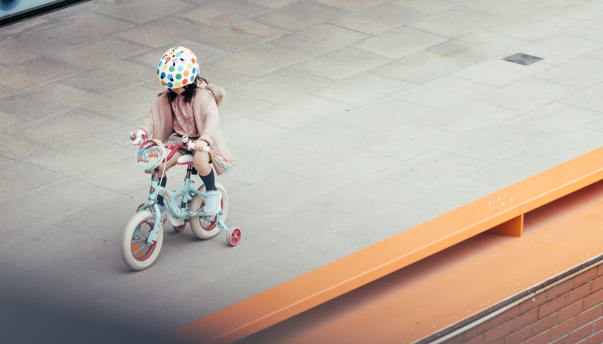 Girl on a bicycle with trainingwheels