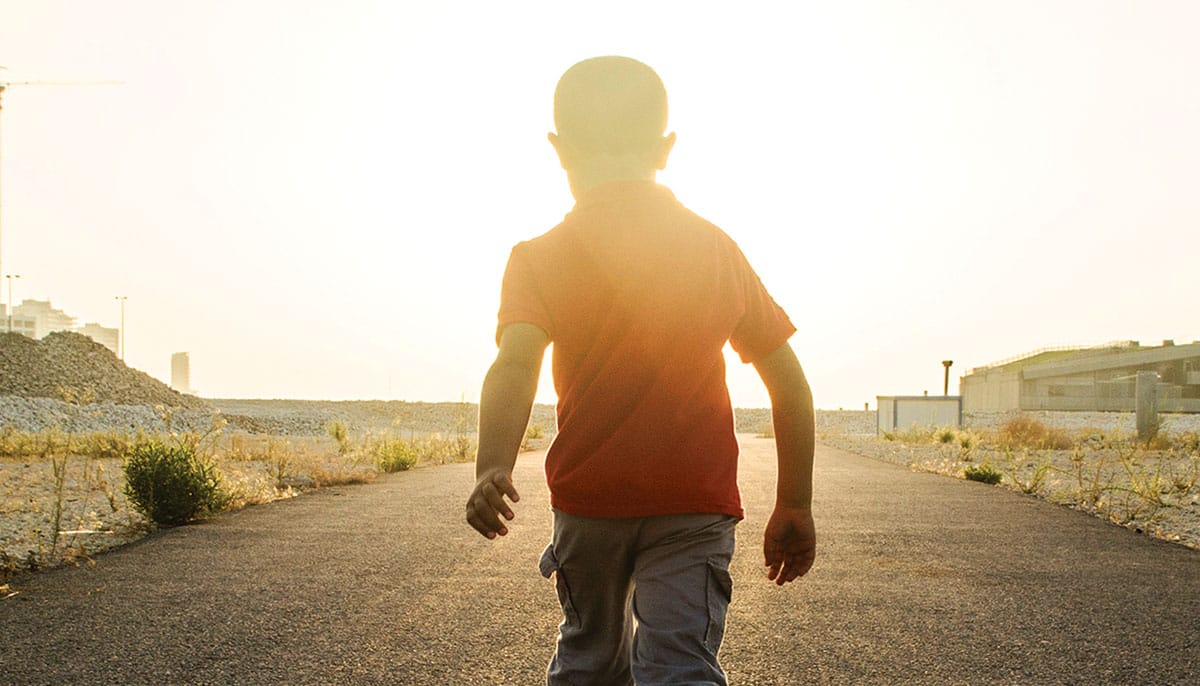 Boy walking into the light.