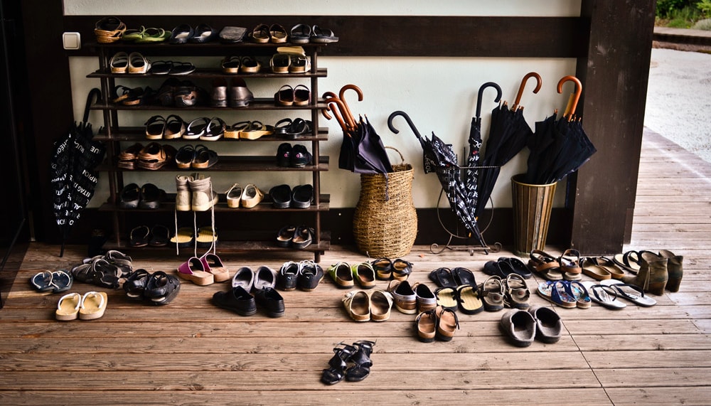 Pile of shoes on a rack outside meditation hall