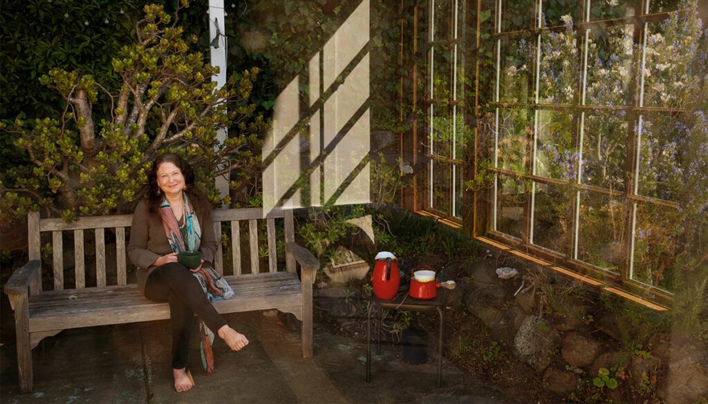 Jane Hirshfield sitting in sunroom on a bench