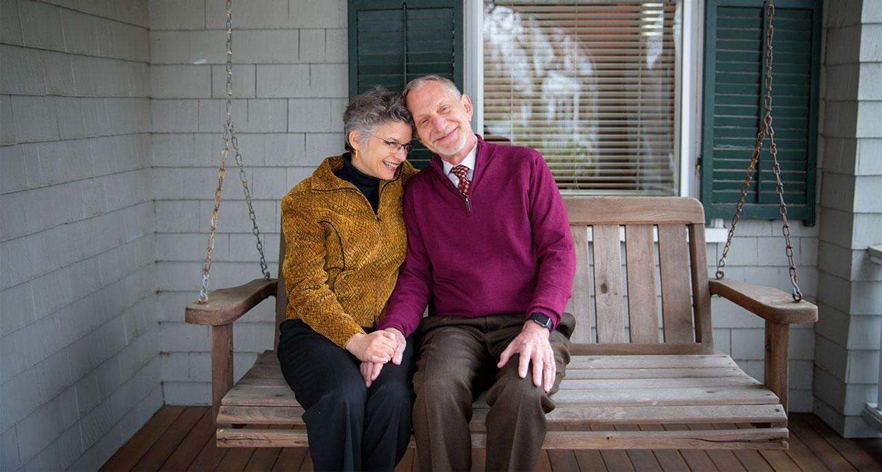 A person and person sitting on a bench

Description automatically generated