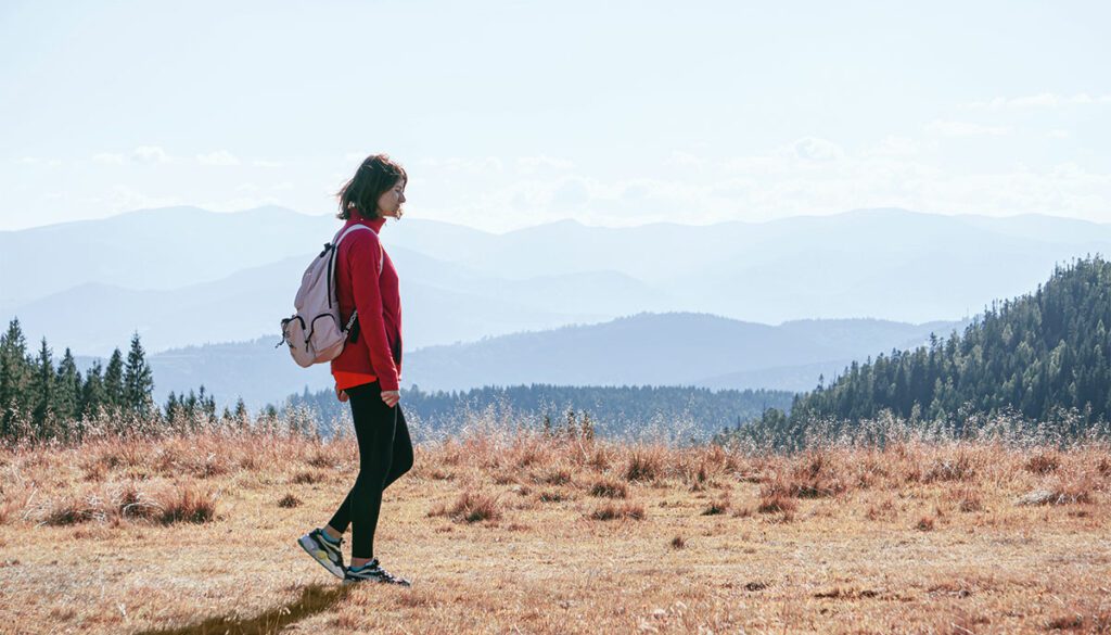 Woman walking through mountain trails.