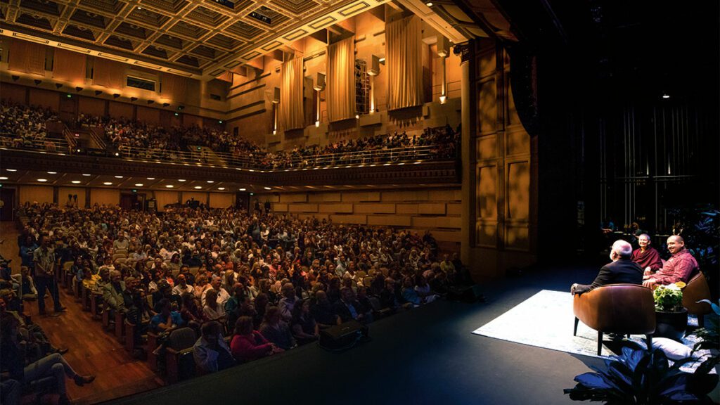 Pema Chodron and Gregory Boyle on stage before an auditorium of people