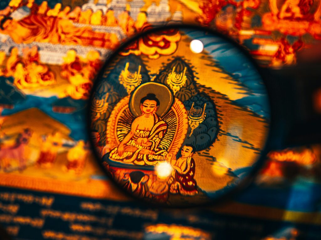 A close-up of a traditional Tibetan-style painting, richly detailed with vibrant colors and intricate patterns, often found in the traditional Tibetan palm leaf texts known as "pechas."