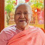 Bhikkhuni Dhammawati Guruma smiles in pink robes