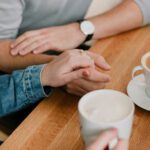 Couple holding hands over coffee
