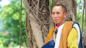 Vietnamese Buddhist monk, Thich Minh Tue, under a tree.
