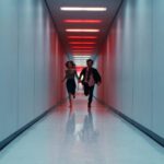 two people running down the long hallway, scene from the Apple TV+ show Severance