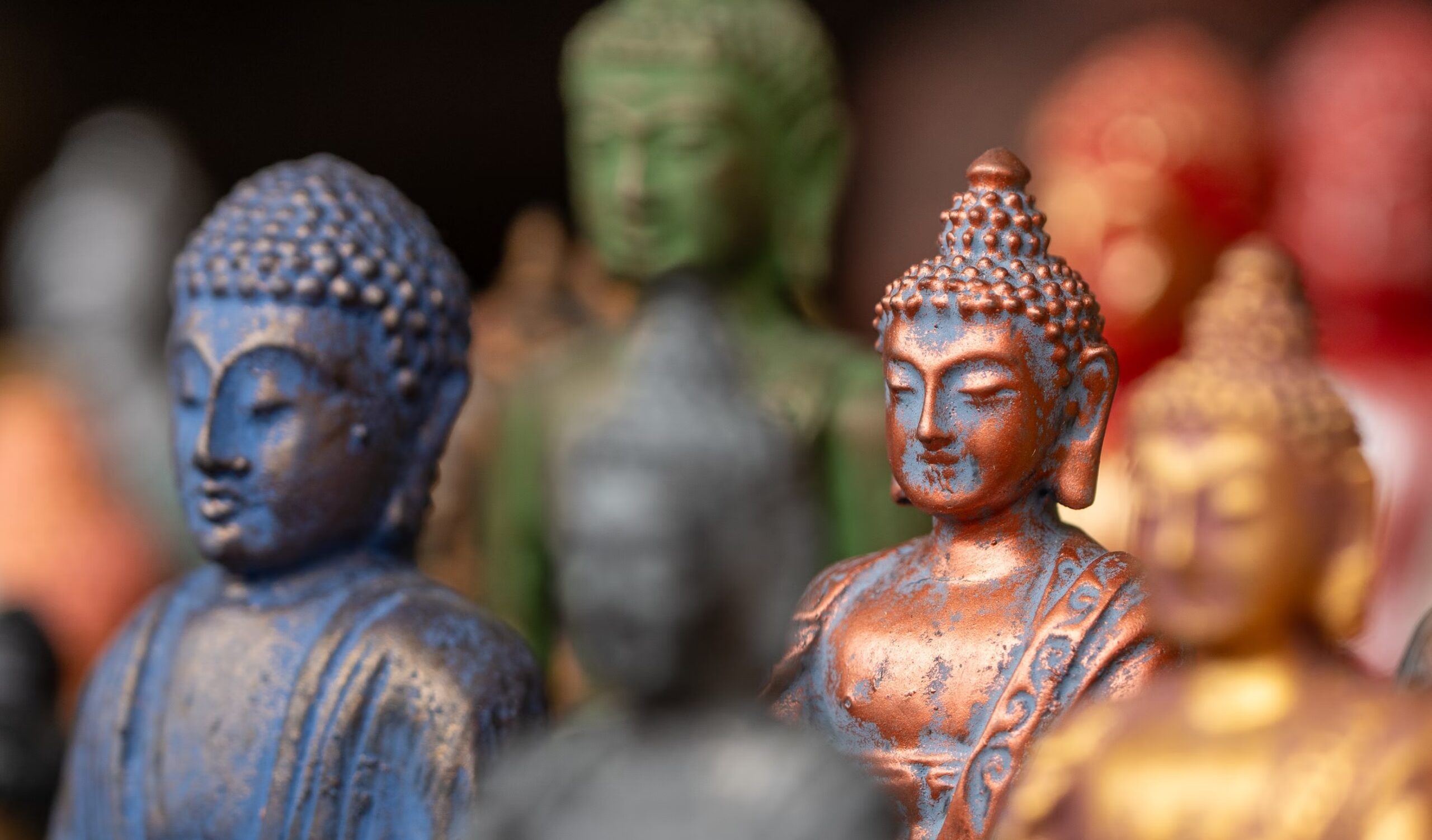 A group of multicolor Buddha statues is depicted.