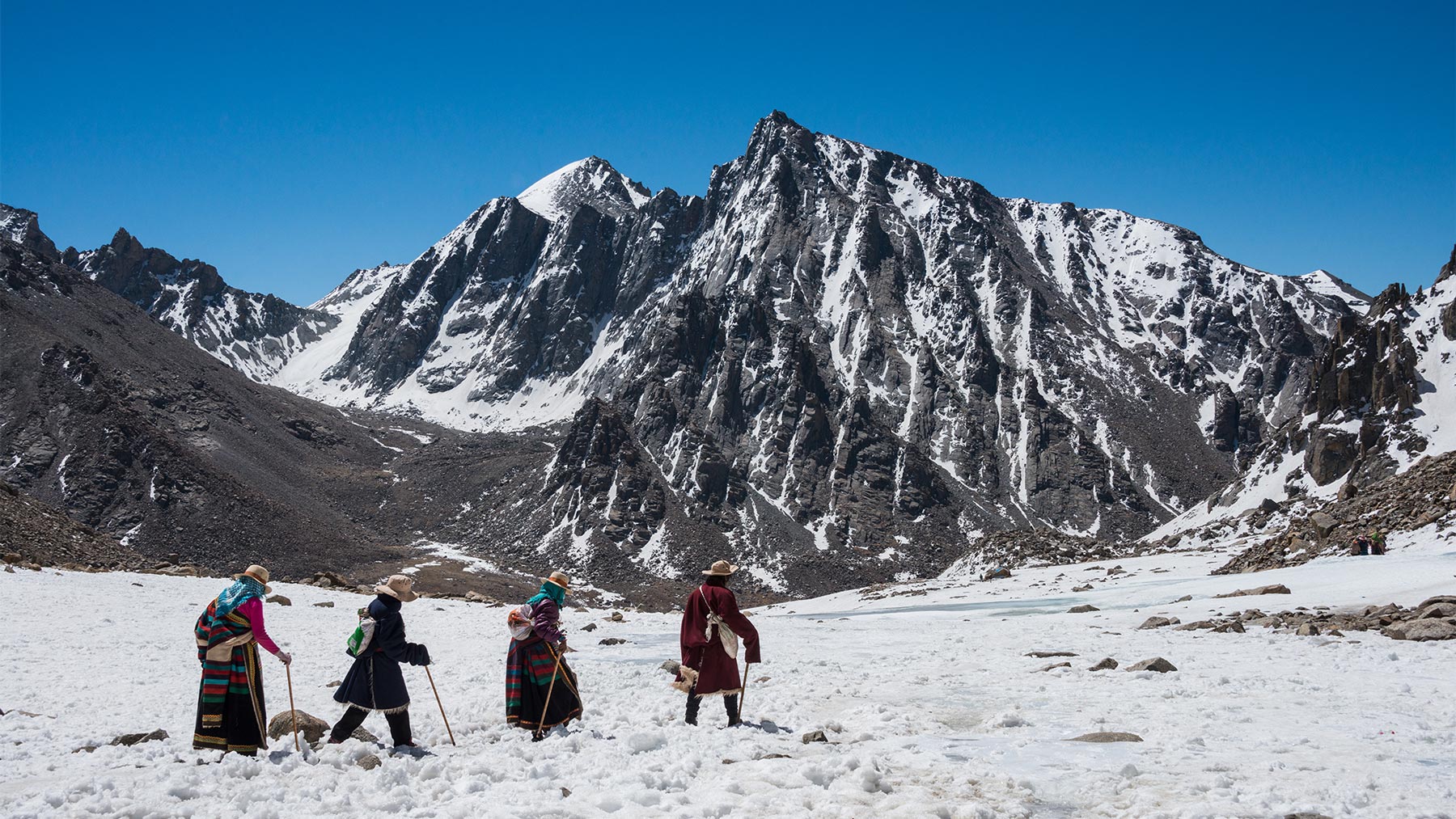 Buddhist pilgrims walking the kora around snowy Mt. Kailash in Tibet.